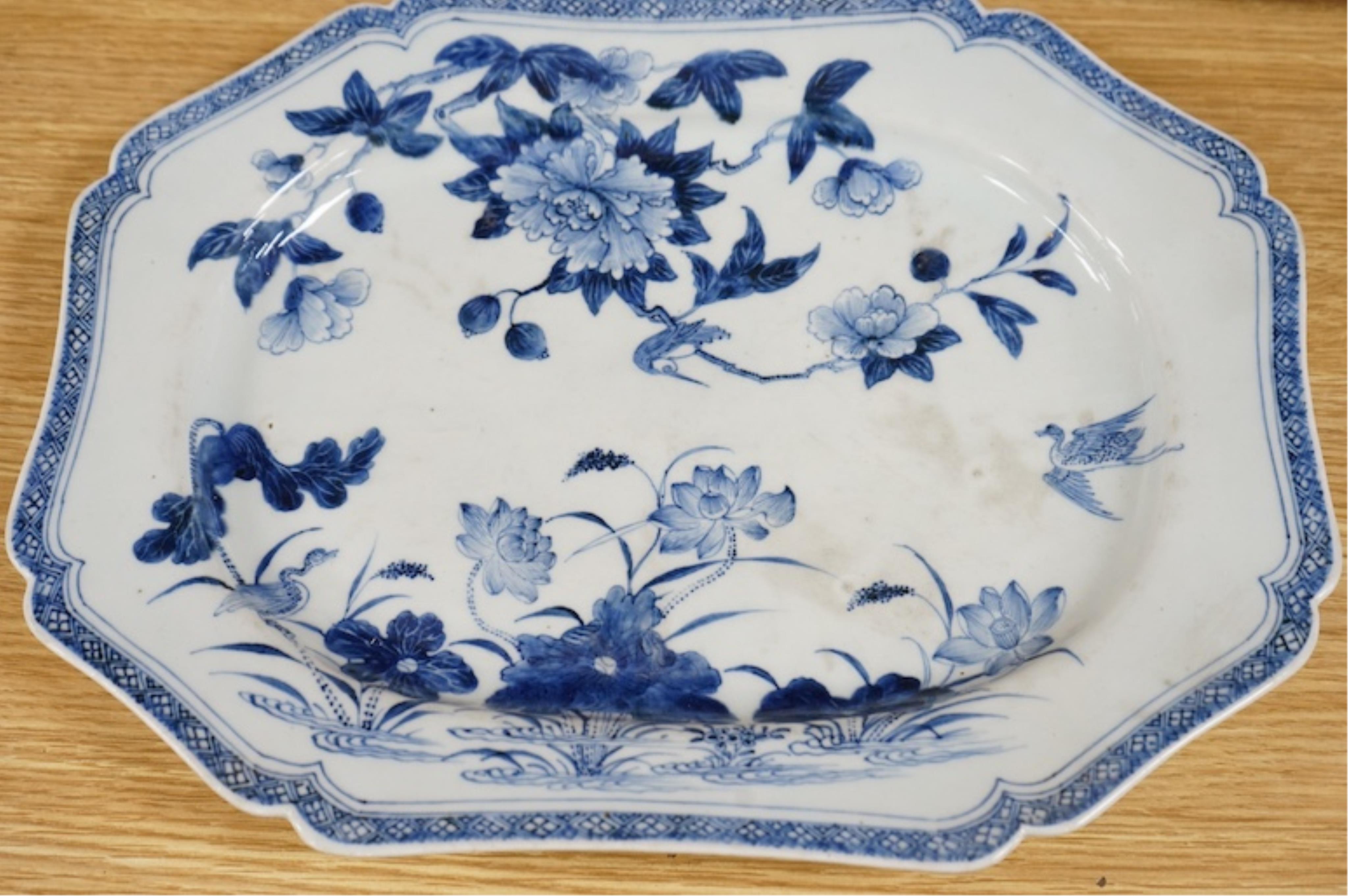 Three 18th century Chinese export blue and white dishes, two decorated with Lotus and peonies, the third with figures in a river landscape scene, Condition - fair to good